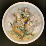 A Continental bisque porcelain circular wall plaque, Huntsman riding above deer catch, 29cm