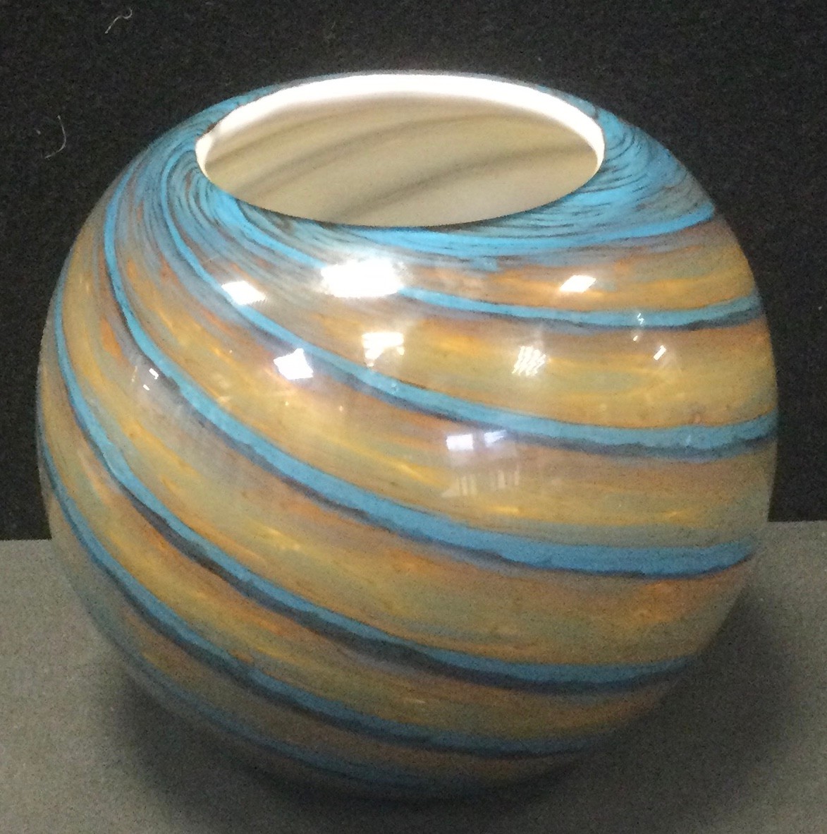 A Whitefriars style spherical form studio range glass vase, with spiralled vortex exterior including