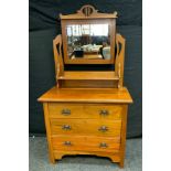 An Arts & Crafts walnut dressing table, central rectangular mirror above a short shelf,