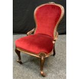 A Victorian mahogany nursing chair, stuffed-over upholstery, cabriole legs, 78cm high.