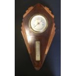 An Art Deco style oak aneroid barometer thermometer, silvered scales, 55cm high, 28cm wide.