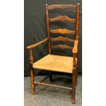 A 19th century elm ladder back armchair, shaped cresting rail, rush seat, 108cm high. c1860.
