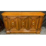 A 20th century mahogany sideboard, cantered top above three cupboard doors enclosing three lining