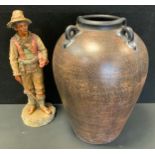 A large terracotta ovoid vase, with four lug handles, 52cm high' a German terracotta figure, of a