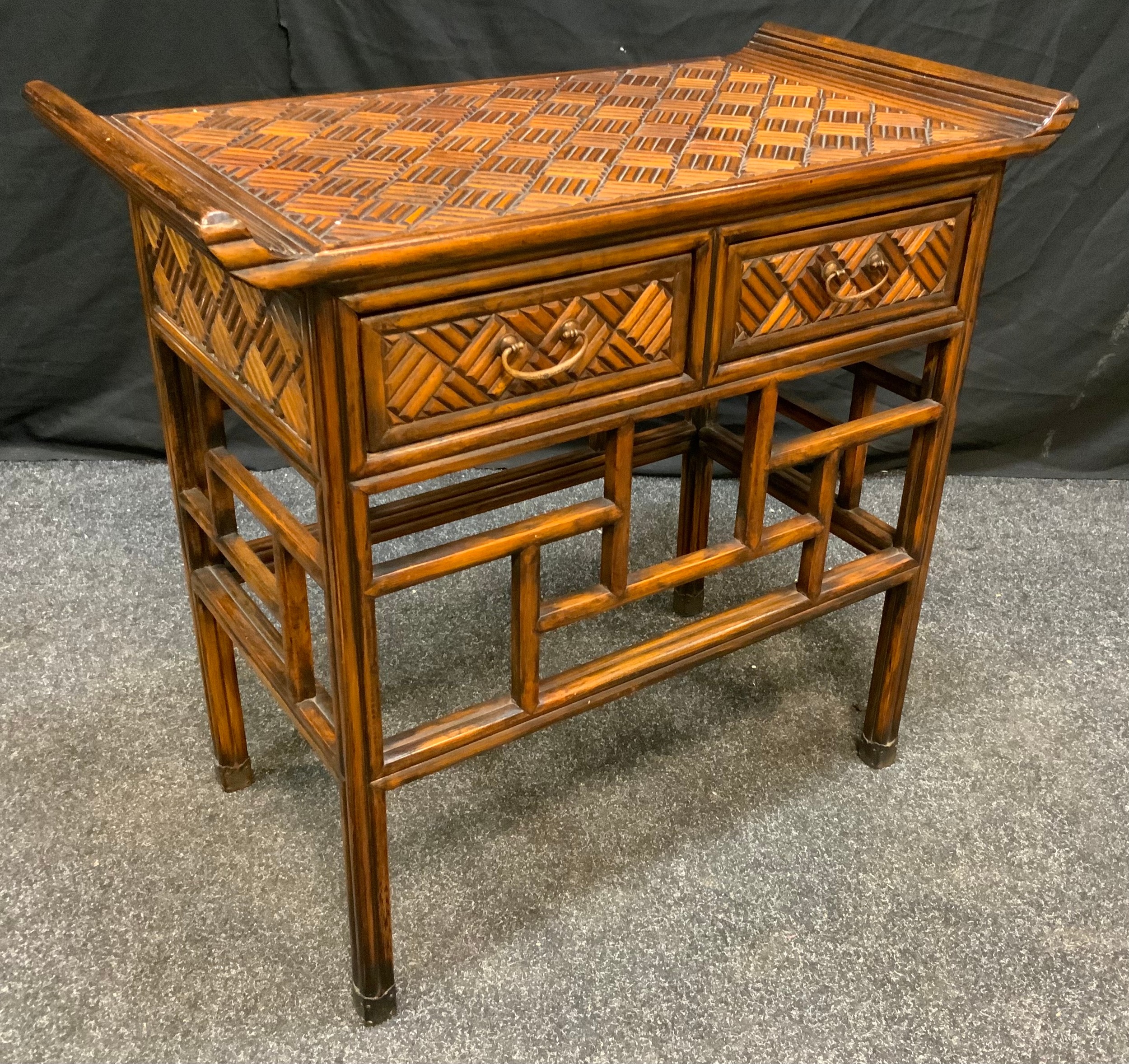 A Reproduction Oriental Style walnut Hall table, carved sleigh-form top above a pair of short