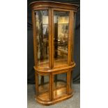 A Contemporary 'Drexel' Style tall bow-front display cabinet, moulded pediment, glazed doors and