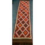 A Persian hand knotted runner, multi coloured geometric lozenge panels, single border, 300cm long,