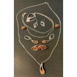 An Ortak 925 silver heart pendant necklace and earrings suite, boxed; a silver and amber pendant,