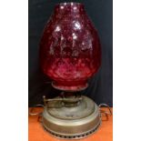 An early 20th century brass 'Thermidor Belge' oil lamp, with cranberry glass shade, 48cm tall.