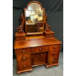 A Victorian Mahogany Dressing Table, the arch-top mirror on carved supports, flanked by two pairs of