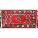 A 20th century Tunisian woollen runner central geome, geometric medallion within triple border,