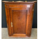 A George III Oak Corner Cupboard, Dentil cornice, paneled door, 98cm tall x 78.5cm wide.