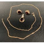 A 9ct gold pendant and chain, with red ruby coloured stone, chain 2.5g; a pair of earrings