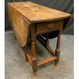 A 19th century oak gateleg table, oval top above a frieze drawer, turned legs, 73cm high, 136cm wide