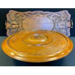 A 20th century carved oak rectangular tray, brass handle, 60cm wide, 28cm deep; a mahogany revolving