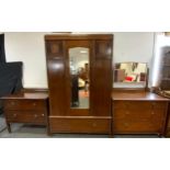 A 20th century oak bedroom suite comprising a double wardrobe with a central bevelled mirrored