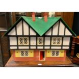 A modern two storey dolls house, green roof, black and white upper storey, plastic fittings, 55cm
