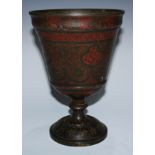 A large Indian dark patinated bronze pedestal cup, chased and decorated with dense scrolling leafy