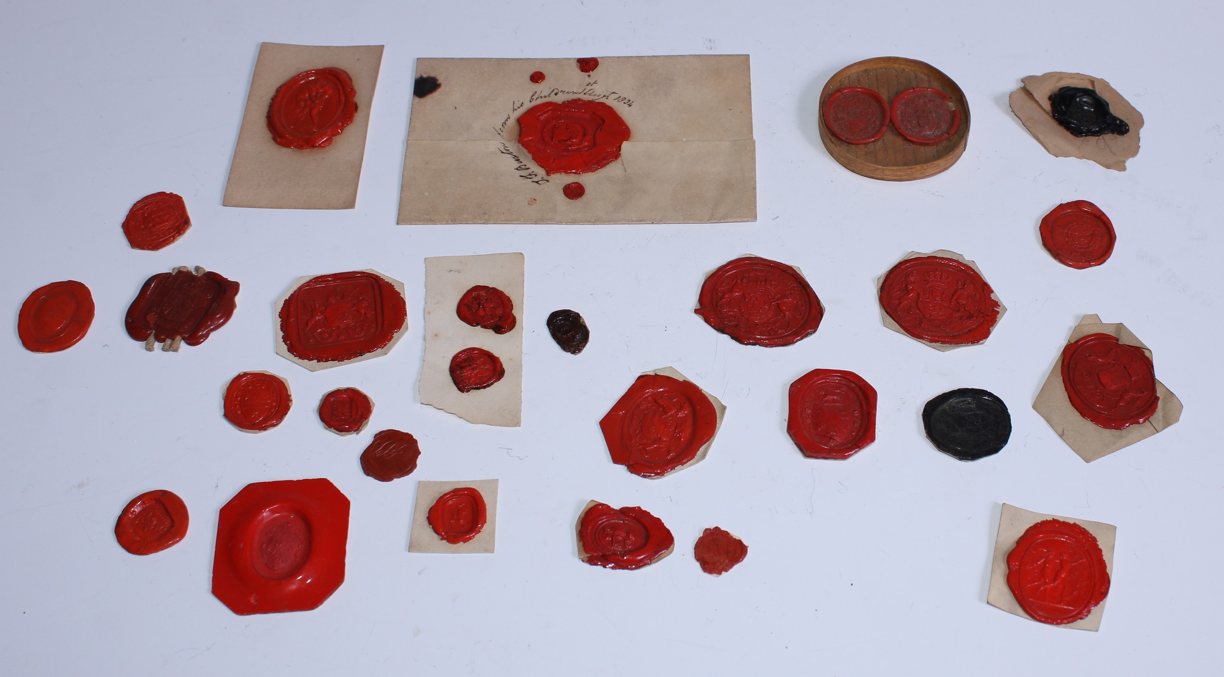 A collection of twenty-eight 18th and early 19th century red wax glyptic intaglio impressions,