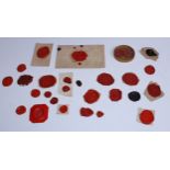 A collection of twenty-eight 18th and early 19th century red wax glyptic intaglio impressions,