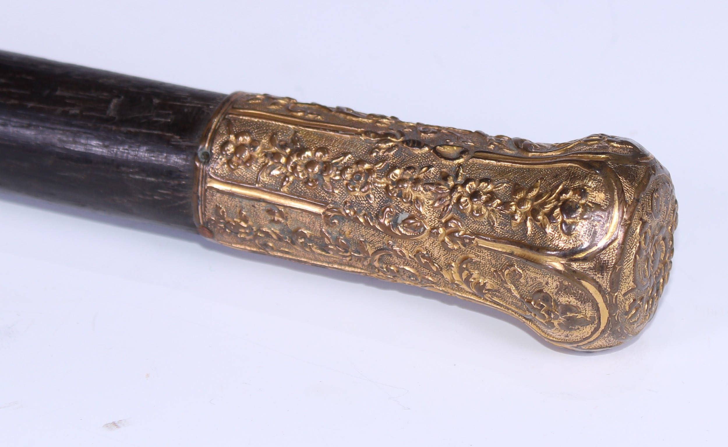 An 18th century gilt metal mounted walking stick, the pommel chased in the Rococo manner with