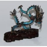 A Chinese silver coloured metal and enamel model, of a ferocious dragon, carved hardwood base,