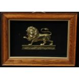 A 19th century gilt metal applique, cast as a heraldic lion passant, oak frame, 38cm x 51.5cm