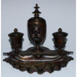 A 19th century patinated bronze inkstand, central ovoid lamp cast in the Grand Tour taste with a