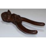 A Black Forest novelty lever-action nut cracker, carved as a gnome, full-length he sits astride,