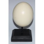 Natural History - an ostrich egg, mounted for display, 24cm high overall