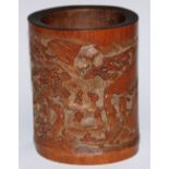 A Chinese bamboo bitong brush pot, well-carved in relief with figures in a monumental landscape,