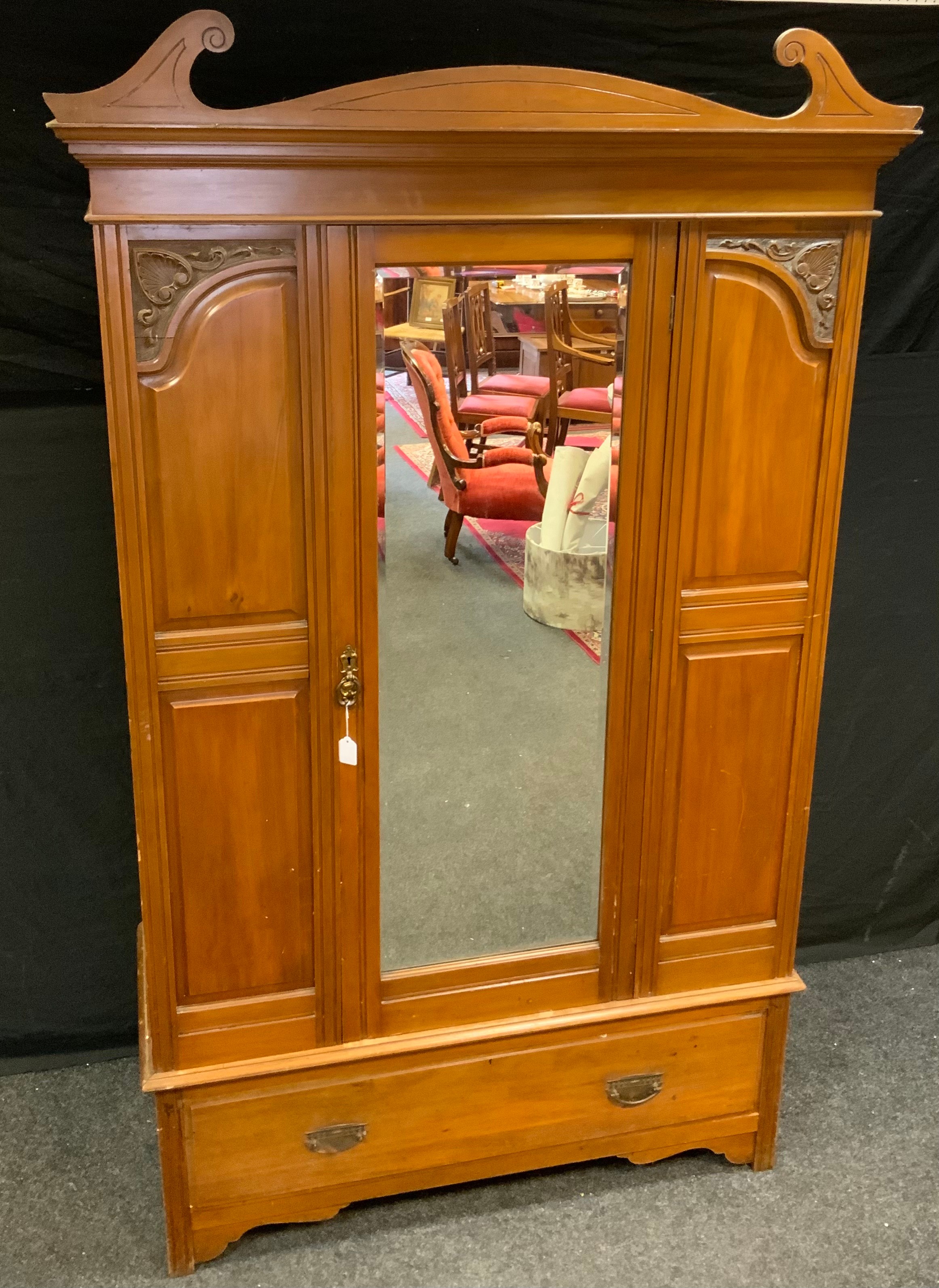 An early 20th Century Mahogany Wardrobe, crested pediment, central door with bevelled mirror, carved