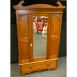 An early 20th Century Mahogany Wardrobe, crested pediment, central door with bevelled mirror, carved