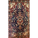 A Hamadan carpet, central geometric medallion in tones of cream, bule and claret, 214cm x 127cm