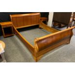 A contemporary mahogany double sledge bed; a pair of contemporary mahogany bedside tables,
