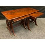 A 20th century mahogany side-by-side nest of tables, out-swept legs, brass lion-paw feet.