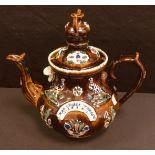 A Victorian barge ware treacle glazed teapot and cover, late 19th century, moulded with pheasant