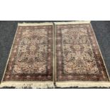 A Pair of Middle Eastern Rugs, knotted in shades of pale puce, brown, and deep blue, each