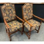 A pair of 21st century oak elbow chairs, the arched back and seats upholstered in Medieval style