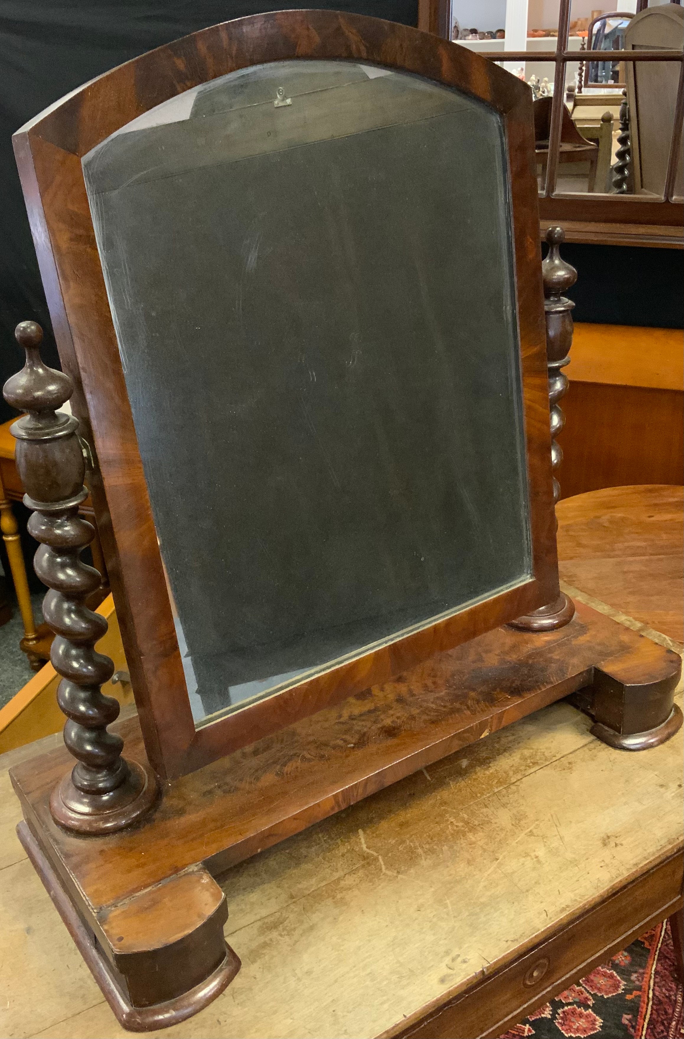An early Victorian mahogany toilet mirror, having an arch-top mirror with barley-twist supports on a