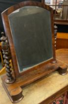 An early Victorian mahogany toilet mirror, having an arch-top mirror with barley-twist supports on a