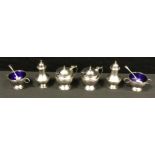 A George V silver six piece cruet set, pair of salts, pair of mustards with Bristol blue glass