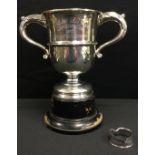 A silver two handled loving cup, central girdle, Sheffield 1960, 17.2ozt (535g); a silver napkin (2)