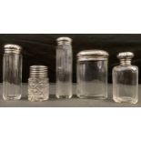 A set of four George V silver dressing table bottles, hammered covers, London 1901; another late