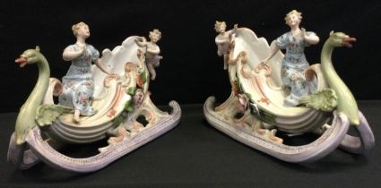 A pair of early 20th century continental porcelain figural sleigh vases, Swans head prows, painted