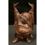 A Chinese boxwood carving of Hotai, he stands smiling with arms aloft, 13cm high.