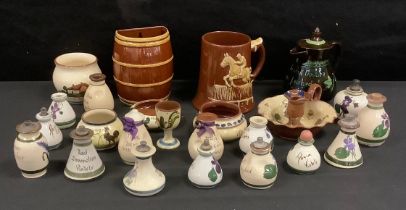 Torquay ware and Devon ware pottery; fourteen perfume bottles, trinket dishes, a candle holder, a