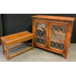 A mid 20th century oak bookcase cabinet, having an oversailing rounded rectangular top above a