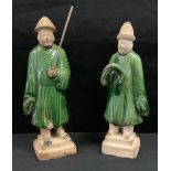 A pair of Chinese Ming style pottery figures, of attendants, standing, green glaze, 25cm high.(2)