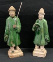 A pair of Chinese Ming style pottery figures, of attendants, standing, green glaze, 25cm high.(2)